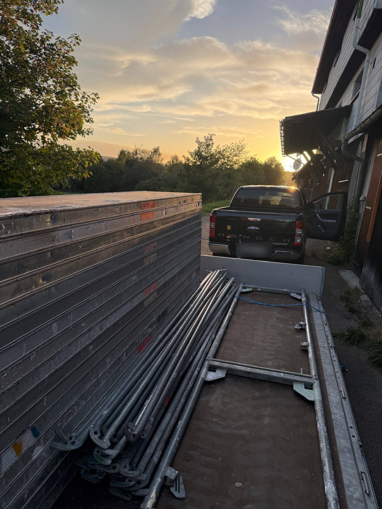 Gerüstmaterial im Sonnenuntergang, bereit für Lieferung und Abholung
