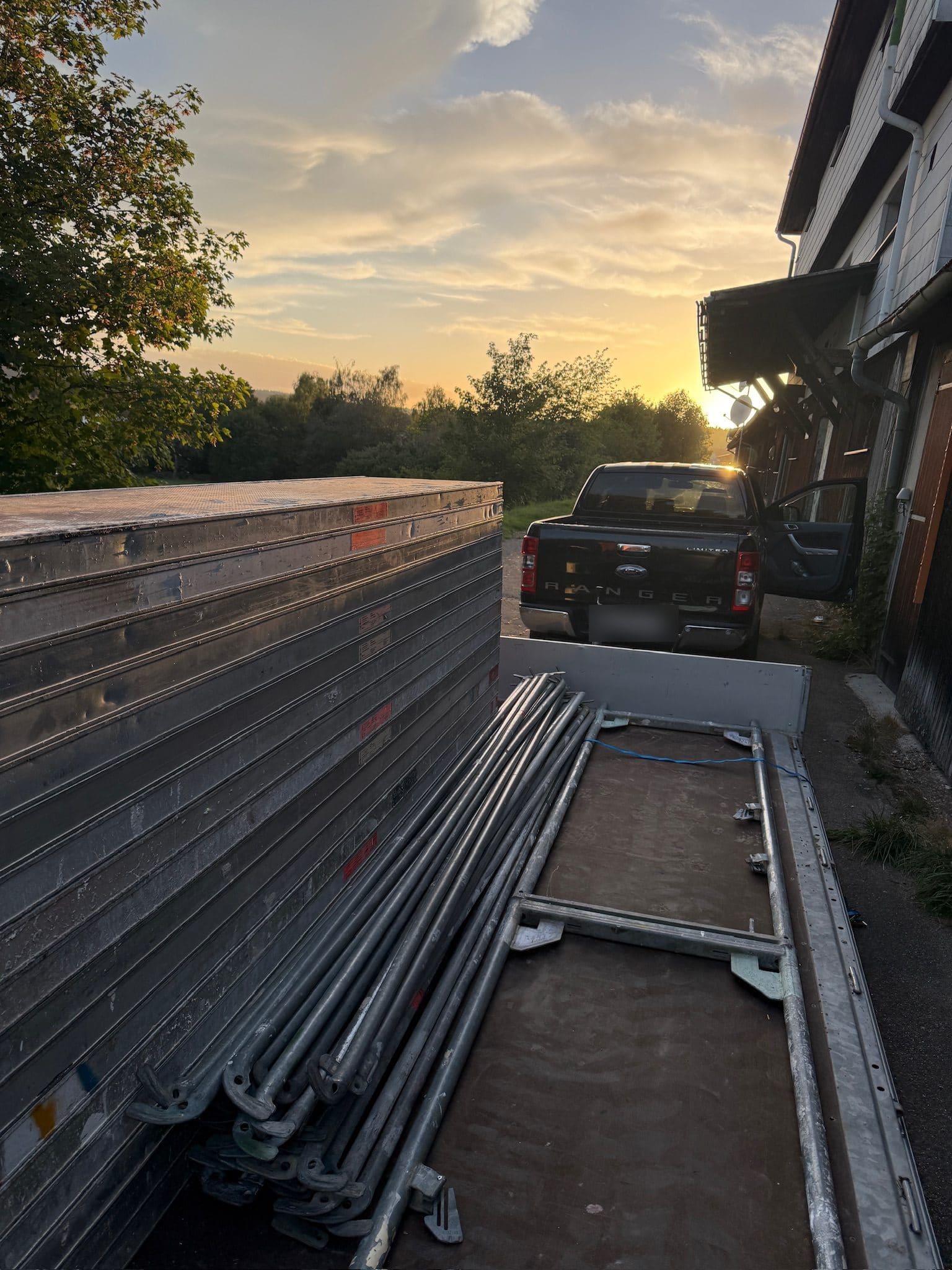 Gerüstmaterial im Sonnenuntergang, bereit für Lieferung und Abholung